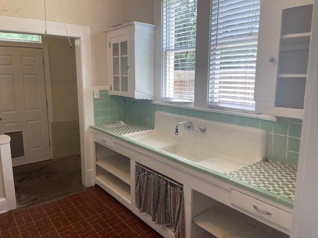 bathroom featuring tasteful backsplash and brick patterned flooring