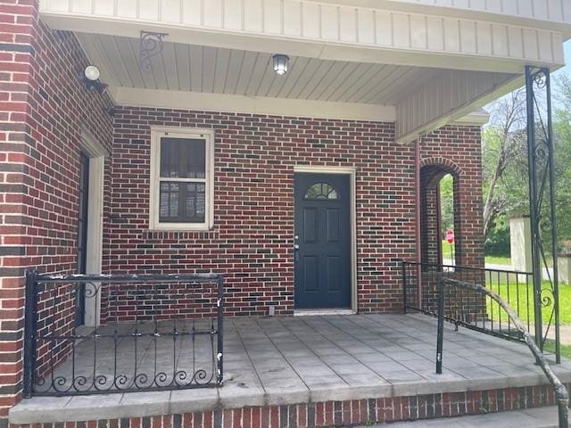 doorway to property featuring brick siding