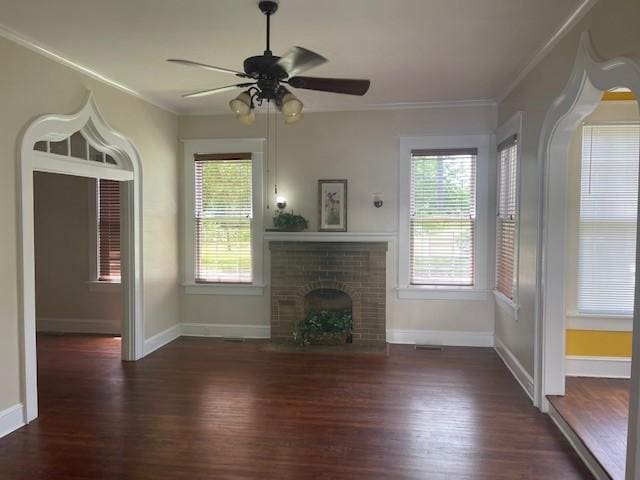 unfurnished living room featuring healthy amount of natural light, wood finished floors, crown molding, and baseboards