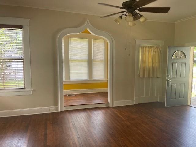 spare room featuring crown molding, wood finished floors, ceiling fan, and baseboards