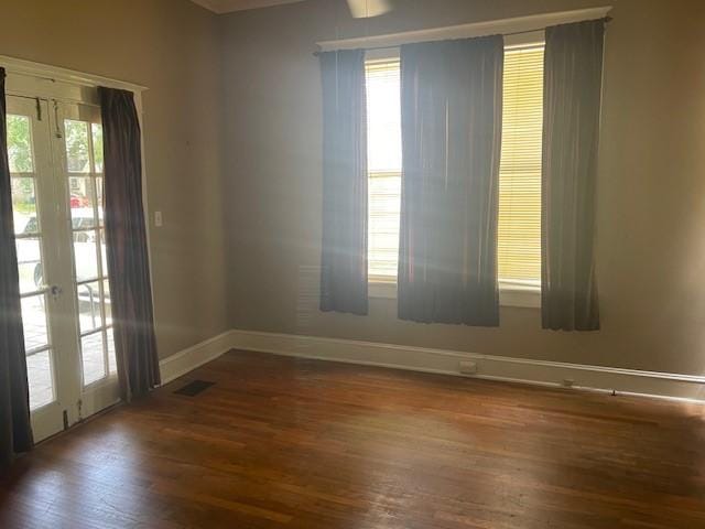 spare room featuring baseboards, wood finished floors, and french doors