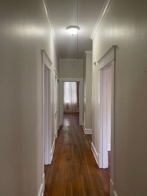 hall featuring ornamental molding, dark wood finished floors, and baseboards
