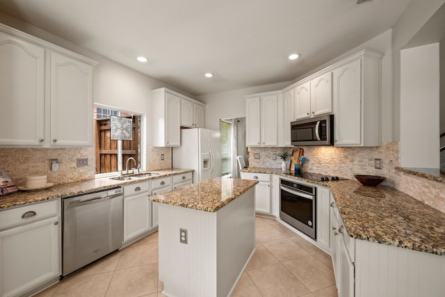 521 Austin Oaks Dr, Grapevine, TX 76051 - kitchen with stainless steel appliances, a sink, stone counters, tasteful backsplash, and white cabinetry