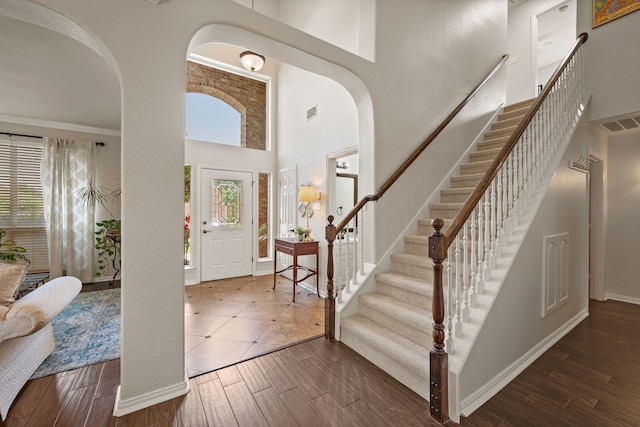 521 Austin Oaks Dr, Grapevine, TX 76051 - foyer entrance with wood finished floors, a towering ceiling, arched walkways, stairs, and baseboards