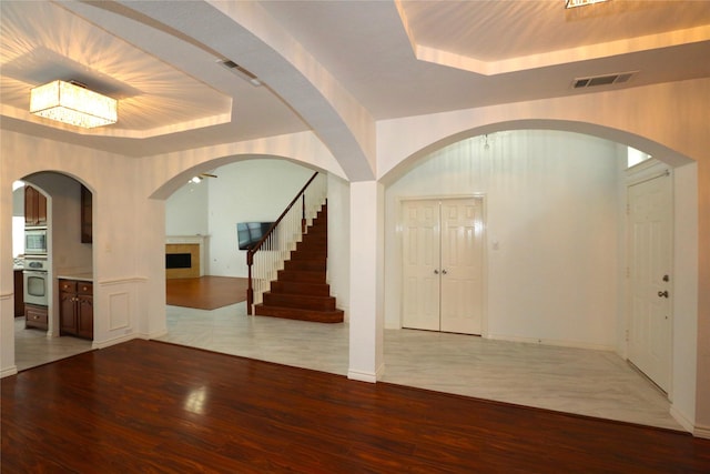 1104 Ruby St, Plano, TX 75094 - entrance foyer featuring a raised ceiling, wood finished floors, stairway, and a fireplace