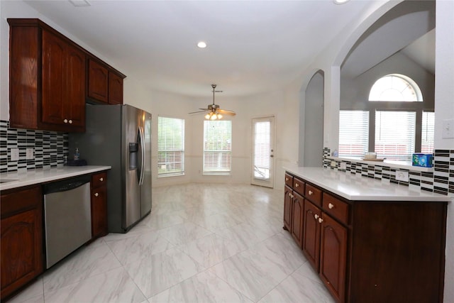 1104 Ruby St, Plano, TX 75094 - kitchen featuring stainless steel appliances, arched walkways, light countertops, tasteful backsplash, and a ceiling fan
