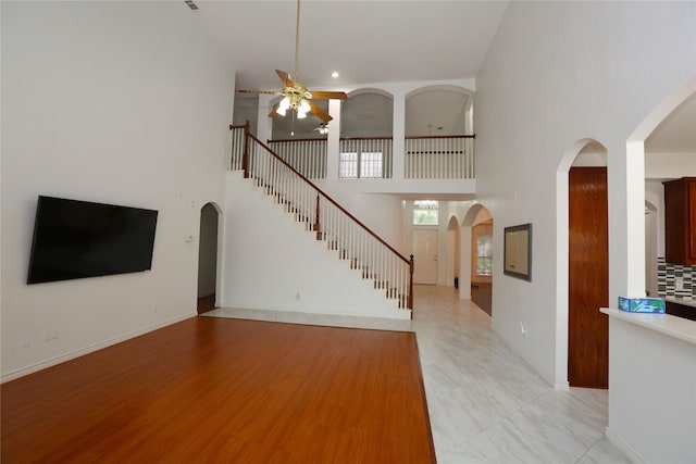 1104 Ruby St, Plano, TX 75094 - unfurnished living room with a ceiling fan, arched walkways, and a high ceiling