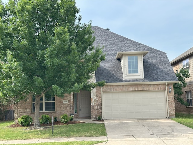 2408 Jill Creek Dr, Little Elm, TX 75068 - view of front of house with concrete driveway, brick siding, a garage, and a shingled roof