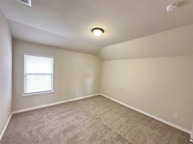 2408 Jill Creek Dr, Little Elm, TX 75068 - bonus room with carpet floors, lofted ceiling, baseboards, and a textured ceiling