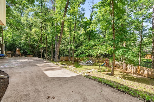 view of patio featuring a playground and fence