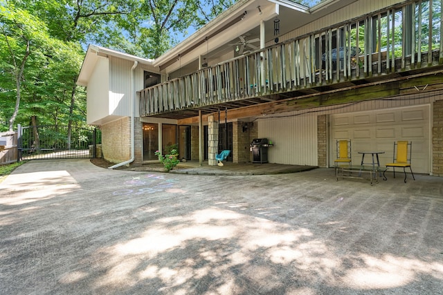 rear view of house with a gate, brick siding, and an attached garage