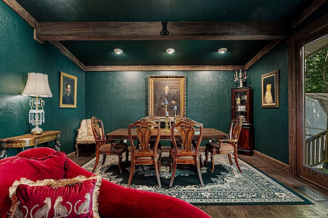dining space with wood finished floors, a textured wall, beam ceiling, baseboards, and ornamental molding