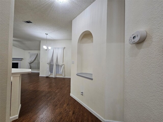 3406 Lake Highlands Dr, Rowlett, TX 75088 - corridor featuring wood finished floors, a textured ceiling, baseboards, a chandelier, and a textured wall
