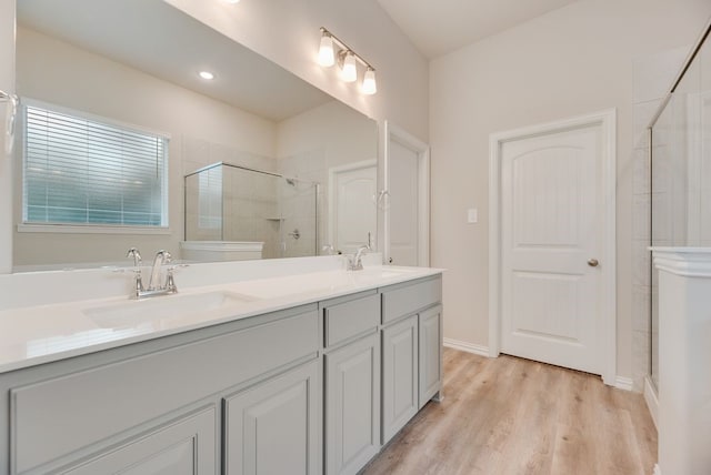 1301 Hickory Ct, Weatherford, TX 76086 - full bathroom featuring tiled shower, double vanity, and wood finished floors