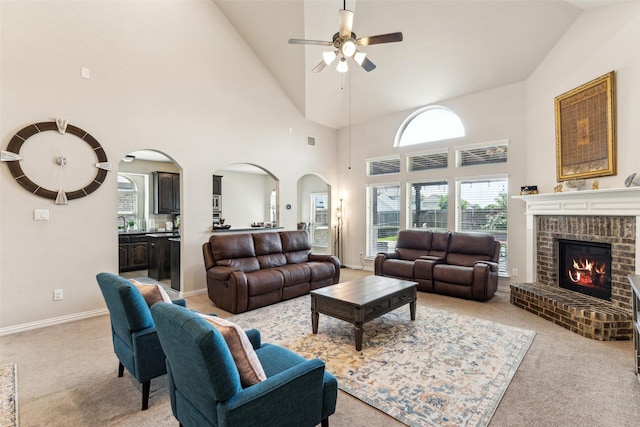2314 Bob Sandlin Ln, Wylie, TX 75098 - living room featuring arched walkways, a ceiling fan, light colored carpet, a brick fireplace, and high vaulted ceiling