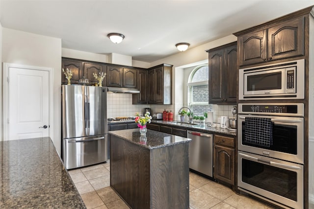 2314 Bob Sandlin Ln, Wylie, TX 75098 - kitchen with stainless steel appliances, a sink, dark brown cabinets, backsplash, and dark stone counters