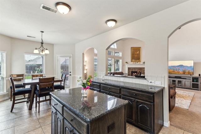 2314 Bob Sandlin Ln, Wylie, TX 75098 - kitchen with dark stone countertops, a kitchen island, and light tile patterned floors