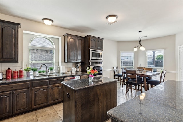 2314 Bob Sandlin Ln, Wylie, TX 75098 - kitchen featuring stainless steel appliances, a sink, light tile patterned flooring, a center island, and backsplash