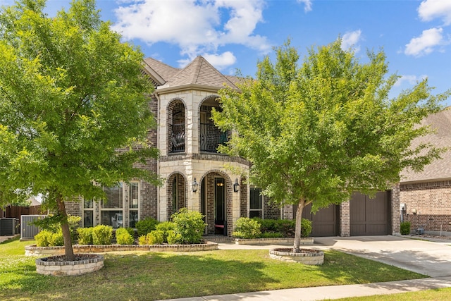 2314 Bob Sandlin Ln, Wylie, TX 75098 - french provincial home featuring driveway, a garage, stone siding, a balcony, and central AC