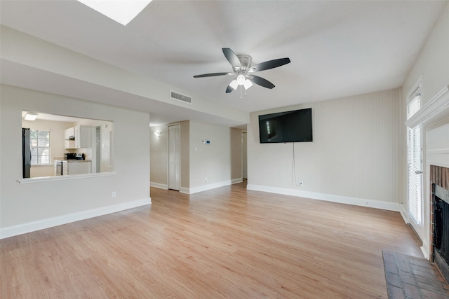 4914 Stagecoach Ln, Garland, TX 75043 - unfurnished living room featuring a brick fireplace, ceiling fan, light wood-style flooring, and baseboards