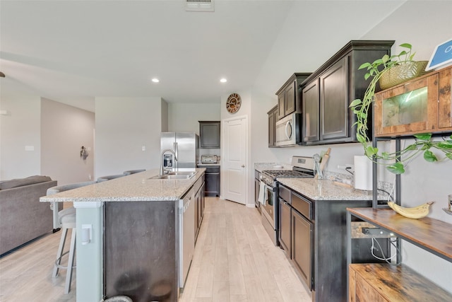 6128 Blacksmith Ave, Fort Worth, TX 76179 - kitchen featuring appliances with stainless steel finishes, light wood-type flooring, a sink, light stone countertops, and recessed lighting