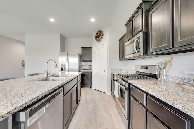 6128 Blacksmith Ave, Fort Worth, TX 76179 - kitchen with stainless steel appliances, light wood-style flooring, light stone counters, recessed lighting, and dark brown cabinets