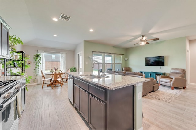 6128 Blacksmith Ave, Fort Worth, TX 76179 - kitchen with a sink, light wood-type flooring, a ceiling fan, a center island with sink, and light stone counters