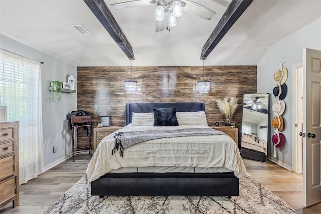 301 Shepherd Ln, Royse City, TX 75189 - bedroom with beam ceiling, light wood-style floors, wood walls, ceiling fan, and baseboards