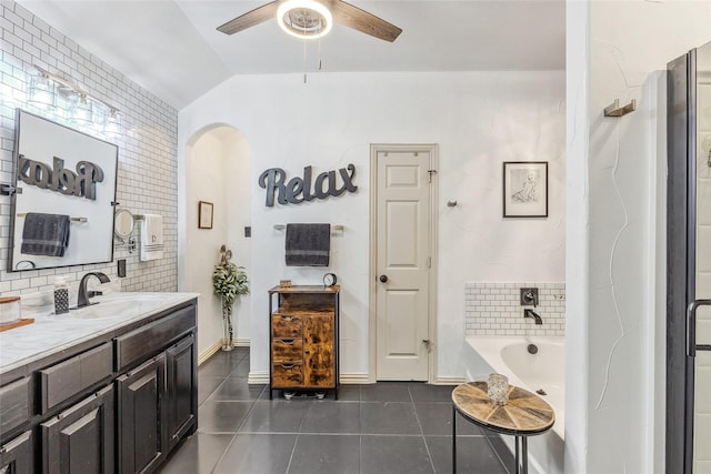 301 Shepherd Ln, Royse City, TX 75189 - bathroom with tile patterned floors, a ceiling fan, a tub, vanity, and vaulted ceiling