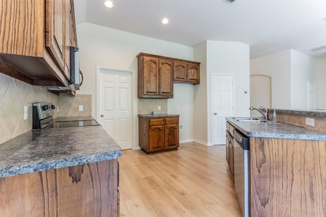 1716 Lake Way Dr, Little Elm, TX 75068 - kitchen with appliances with stainless steel finishes, light wood-style flooring, a sink, tasteful backsplash, and brown cabinetry