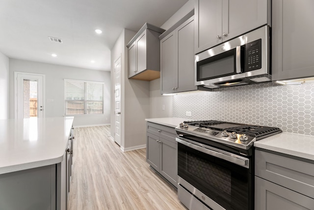 3510 Riley St, Fate, TX 75087 - kitchen with stainless steel appliances, gray cabinets, light countertops, backsplash, and recessed lighting
