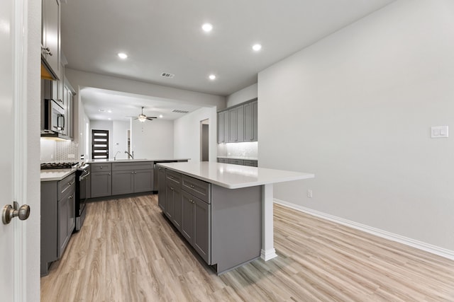 3510 Riley St, Fate, TX 75087 - kitchen featuring gray cabinets, appliances with stainless steel finishes, ceiling fan, light wood-style flooring, and a sink