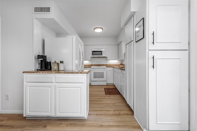 5845 E University Blvd Unit A, Dallas, TX 75206 - kitchen featuring white appliances, light wood finished floors, white cabinetry, and baseboards