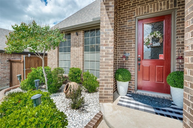 5912 Trail Marker Ct, Fort Worth, TX 76123 - view of exterior entry featuring brick siding, fence, and roof with shingles
