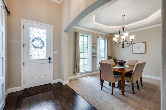 5912 Trail Marker Ct, Fort Worth, TX 76123 - dining room with a chandelier, dark wood-style floors, crown molding, a raised ceiling, and arched walkways