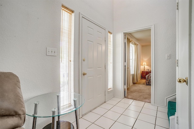 1409 Robyn Rd, Azle, TX 76020 - foyer with healthy amount of natural light, light tile patterned flooring, light carpet, and a textured wall