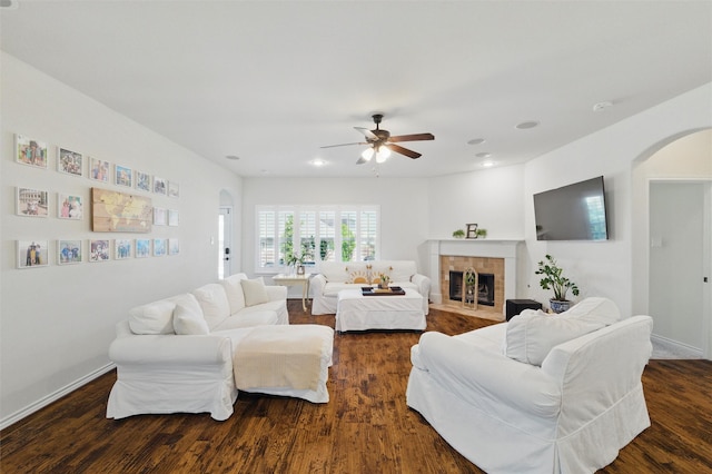 111 Blue Stem Ln, Aledo, TX 76008 - living area with arched walkways, ceiling fan, dark wood-style floors, a tiled fireplace, and baseboards