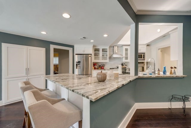 9178 Glen Springs Dr, Dallas, TX 75243 - kitchen featuring appliances with stainless steel finishes, wall chimney exhaust hood, white cabinets, crown molding, and tasteful backsplash