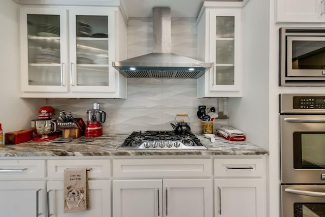 9178 Glen Springs Dr, Dallas, TX 75243 - kitchen with wall chimney exhaust hood, appliances with stainless steel finishes, white cabinetry, and tasteful backsplash