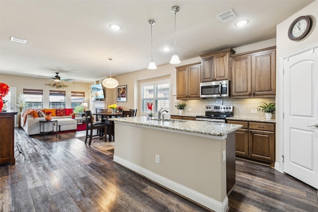 619 Comal Dr, Crandall, TX 75114 - kitchen featuring stainless steel appliances, dark wood-type flooring, a sink, light stone countertops, and tasteful backsplash