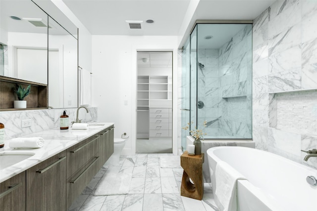 3130 N Harwood St Unit 903, Dallas, TX 75201 - bathroom featuring a stall shower, a freestanding bath, marble finish floors, double vanity, and a spacious closet