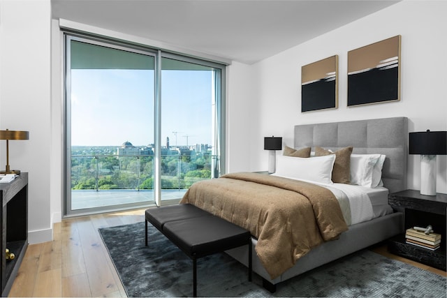 3130 N Harwood St Unit 903, Dallas, TX 75201 - bedroom with expansive windows, multiple windows, access to exterior, and light wood-style floors