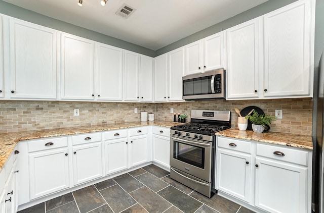 9305 Manassas Rdg, Mckinney, TX 75071 - kitchen with stainless steel appliances, white cabinetry, decorative backsplash, stone finish floors, and light stone countertops
