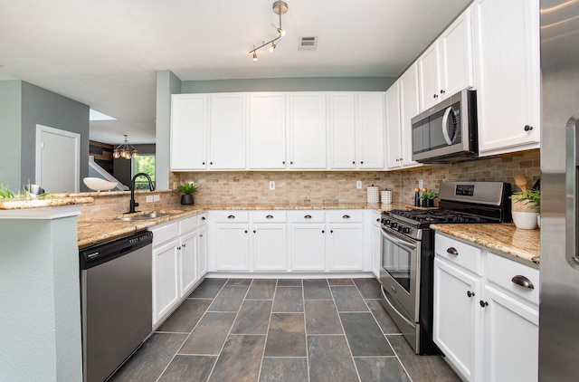 9305 Manassas Rdg, Mckinney, TX 75071 - kitchen with appliances with stainless steel finishes, a sink, white cabinets, decorative backsplash, and a peninsula