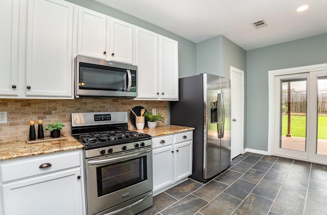 9305 Manassas Rdg, Mckinney, TX 75071 - kitchen with appliances with stainless steel finishes, backsplash, white cabinetry, and baseboards