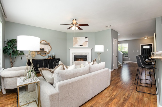 9305 Manassas Rdg, Mckinney, TX 75071 - living room featuring a ceiling fan, wood finished floors, baseboards, and a stone fireplace
