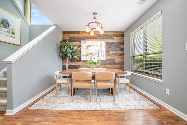9305 Manassas Rdg, Mckinney, TX 75071 - dining room featuring wood walls, a chandelier, stairs, wood finished floors, and baseboards