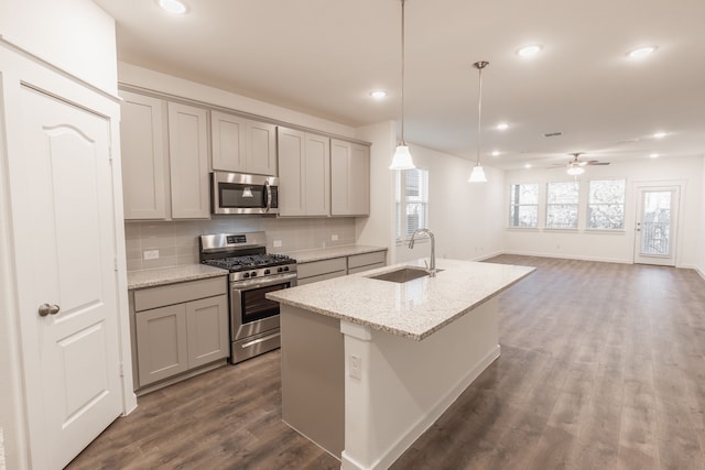2506 Sun Grove Rd, Melissa, TX 75454 - kitchen featuring stainless steel appliances, a sink, gray cabinets, backsplash, and an island with sink