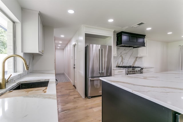 203 Oak Valley Dr, Colleyville, TX 76034 - kitchen with high end appliances, a sink, light stone countertops, light wood finished floors, and recessed lighting