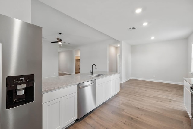 1005 Pecan Pl, Hutchins, TX 75141 - kitchen with stainless steel appliances, a sink, white cabinetry, recessed lighting, and light wood-style flooring